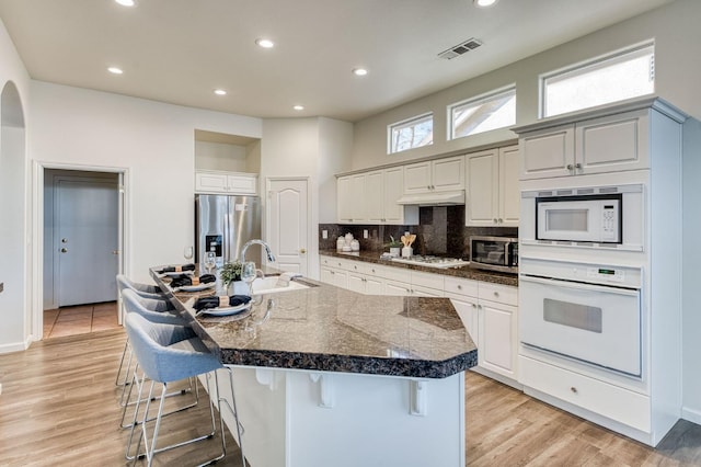 kitchen with appliances with stainless steel finishes, a large island, sink, and a breakfast bar