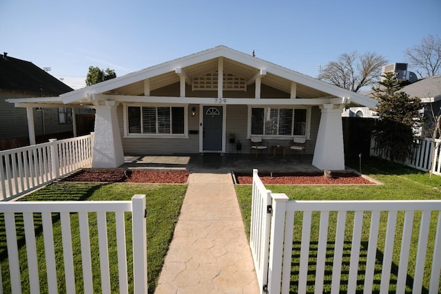 view of front of property featuring covered porch, central air condition unit, and a front yard