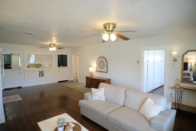 living room with ceiling fan and dark wood-type flooring