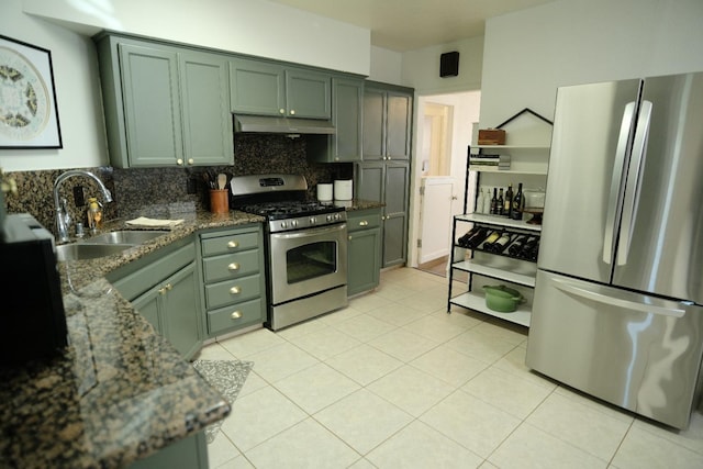 kitchen with dark stone counters, sink, light tile patterned floors, appliances with stainless steel finishes, and tasteful backsplash