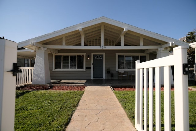 view of front of property with covered porch and a front yard