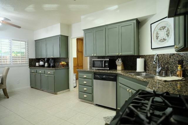 kitchen featuring tasteful backsplash, sink, dark stone counters, and appliances with stainless steel finishes