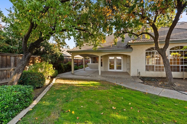 back of property featuring a yard, a patio, and french doors