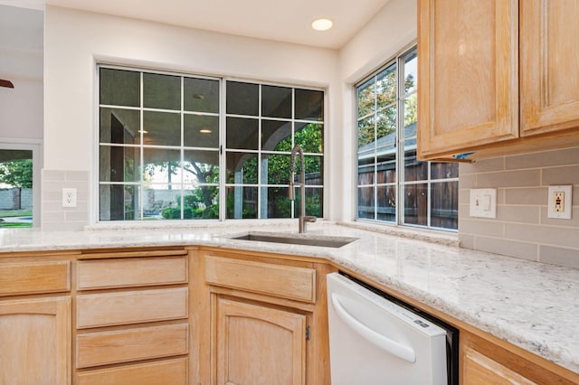 kitchen featuring dishwasher, sink, light brown cabinetry, and tasteful backsplash