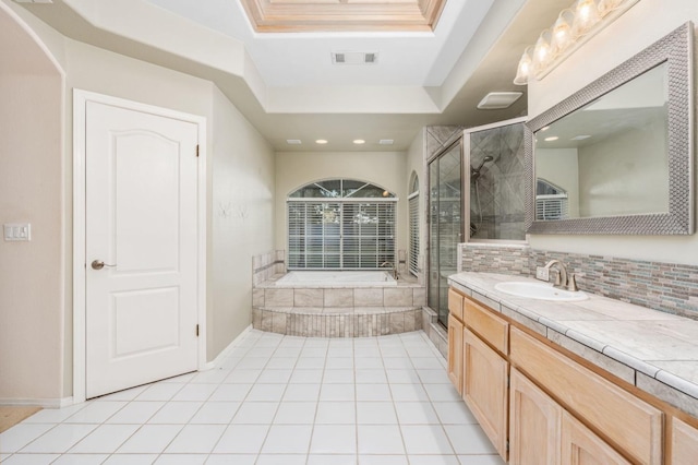 bathroom with vanity, a raised ceiling, a skylight, tile patterned flooring, and independent shower and bath