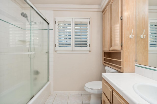 full bathroom with combined bath / shower with glass door, vanity, tile patterned floors, and toilet