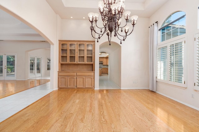 unfurnished living room featuring light hardwood / wood-style floors and an inviting chandelier