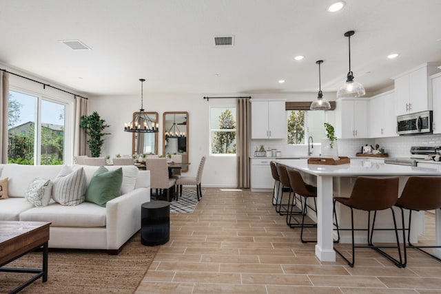 kitchen featuring visible vents, a wealth of natural light, backsplash, and stainless steel appliances
