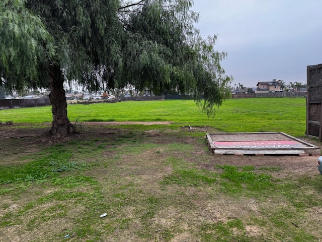 view of home's community with fence and a yard