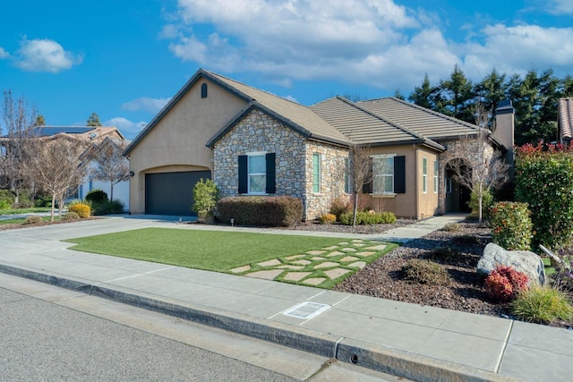 ranch-style home featuring a garage and a front lawn