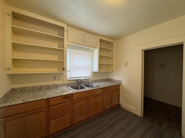 kitchen with a textured ceiling, sink, and dark hardwood / wood-style floors