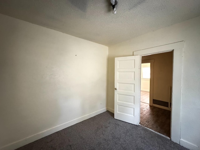 carpeted spare room with a textured ceiling