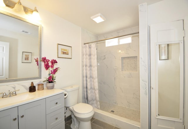 bathroom featuring toilet, vanity, and walk in shower