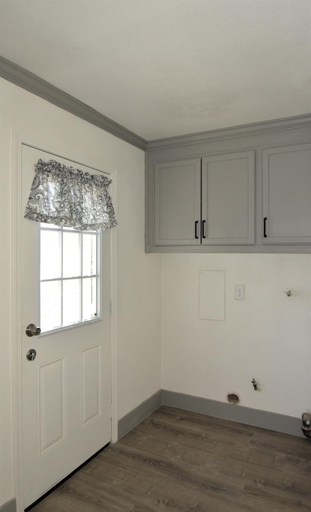 laundry room with crown molding, cabinets, hookup for a gas dryer, and wood-type flooring