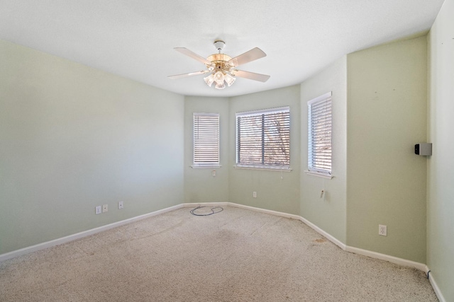 spare room with light colored carpet and ceiling fan