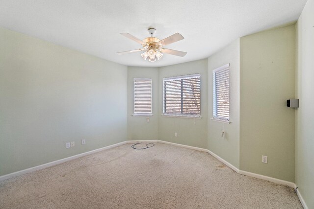 spare room featuring a ceiling fan, baseboards, and carpet