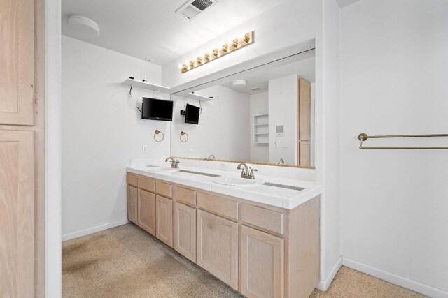 full bath featuring visible vents, a sink, baseboards, and double vanity