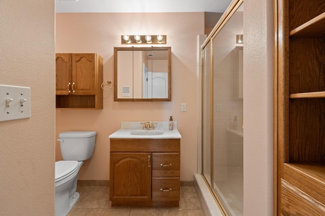 bathroom featuring toilet, vanity, tile patterned floors, and an enclosed shower