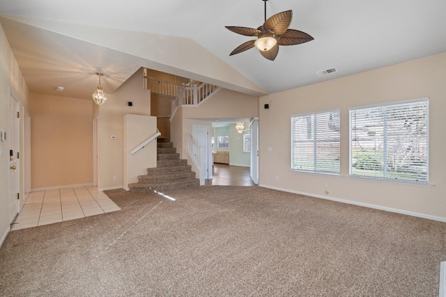 unfurnished living room with light carpet, ceiling fan with notable chandelier, and vaulted ceiling