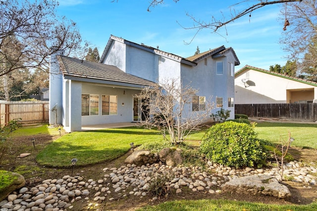 rear view of house featuring a lawn