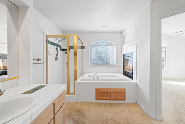 bathroom featuring ceiling fan, vanity, and independent shower and bath