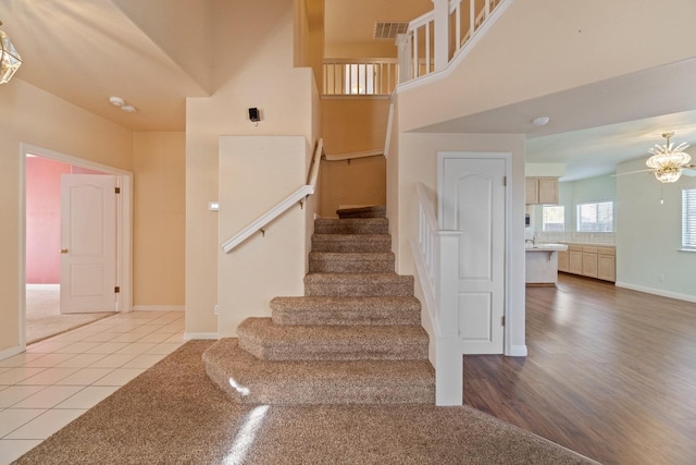 staircase featuring tile patterned floors and a chandelier