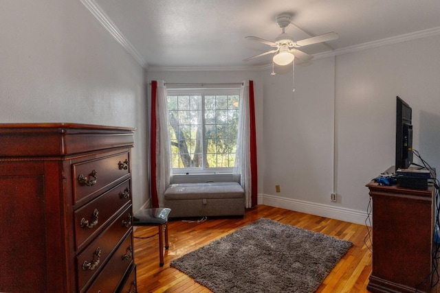 sitting room with ceiling fan, light hardwood / wood-style floors, and ornamental molding
