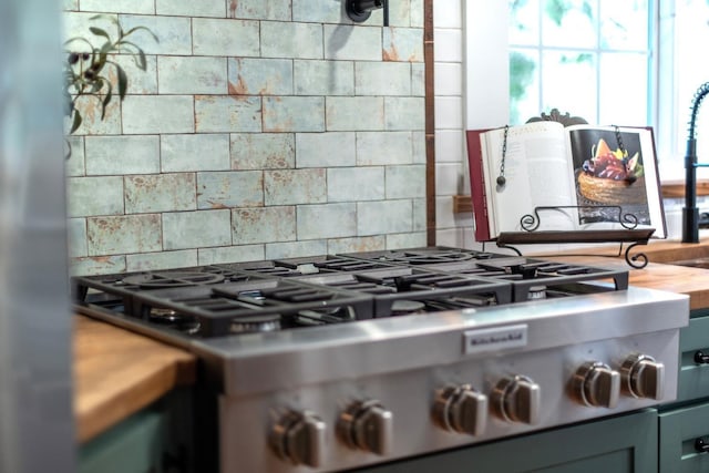 room details featuring stainless steel gas stovetop, decorative backsplash, and stove