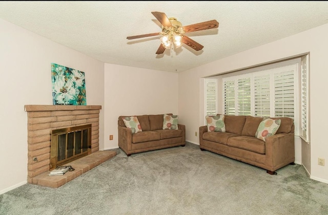 living room with ceiling fan, a fireplace, light colored carpet, and a textured ceiling