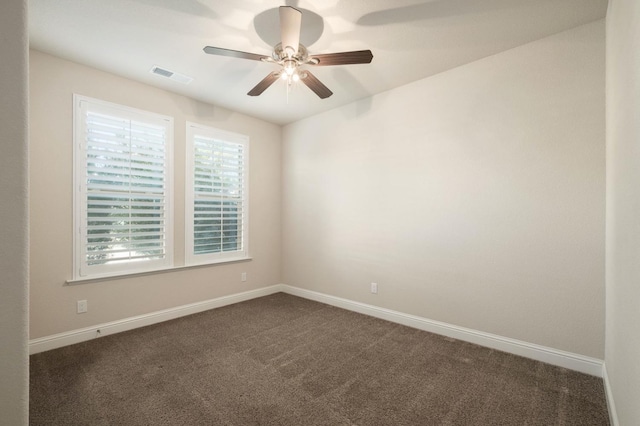 unfurnished room with ceiling fan and dark carpet