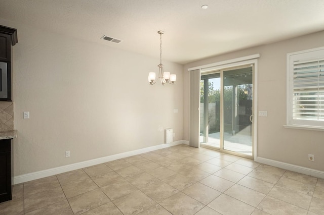 unfurnished dining area with light tile patterned flooring and a chandelier