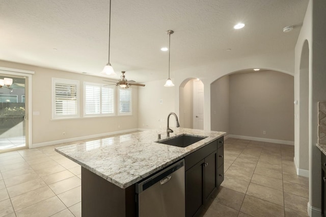 kitchen featuring ceiling fan, sink, stainless steel dishwasher, an island with sink, and pendant lighting