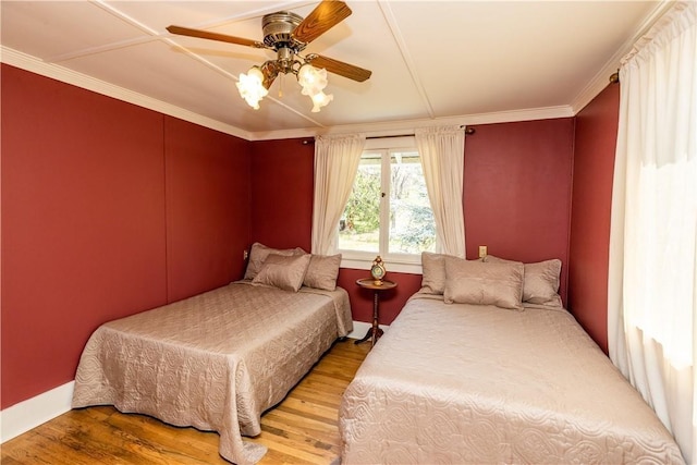 bedroom featuring ceiling fan, wood finished floors, and crown molding