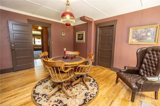 dining area with baseboards, ornamental molding, and wood finished floors