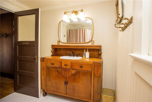 bathroom featuring a shower with shower curtain, vanity, and crown molding