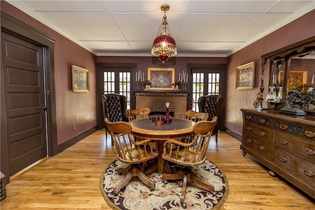 dining space featuring light wood finished floors, plenty of natural light, and ornamental molding