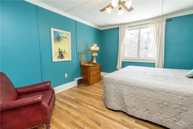 bedroom featuring wood finished floors, visible vents, baseboards, a ceiling fan, and crown molding