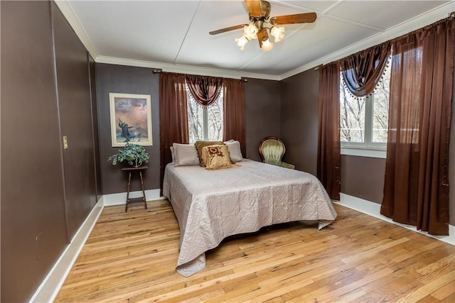 bedroom with light wood-style floors, ornamental molding, and baseboards