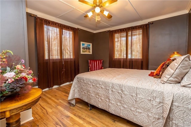 bedroom featuring ceiling fan, wood finished floors, and crown molding