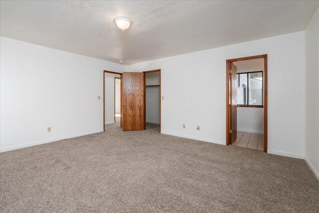 39627 Brandywine Ln, Oakhurst, CA 93644 - unfurnished bedroom with carpet, a textured ceiling, and connected bathroom