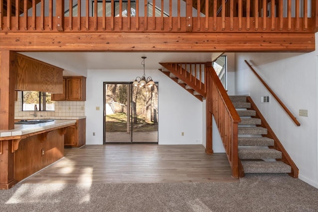 39627 Brandywine Ln, Oakhurst, CA 93644 - kitchen featuring tile counters, brown cabinetry, backsplash, a chandelier, and a breakfast bar area