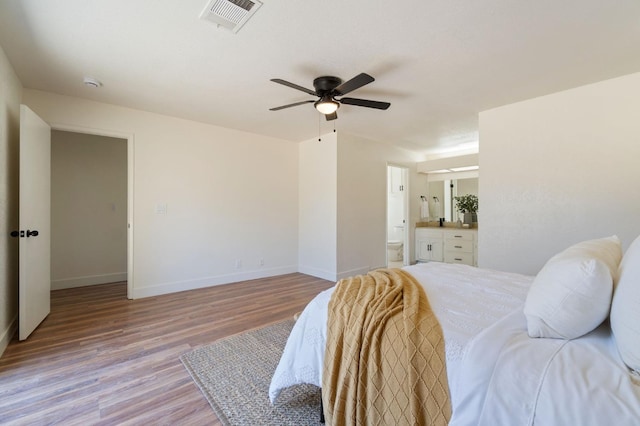 bedroom with ensuite bathroom, ceiling fan, and light hardwood / wood-style flooring