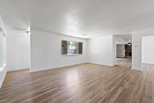 unfurnished room featuring dark wood-type flooring and a textured ceiling