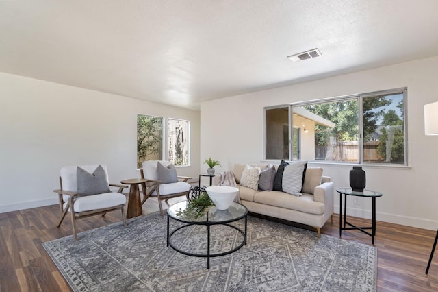 living room featuring a textured ceiling and dark hardwood / wood-style flooring