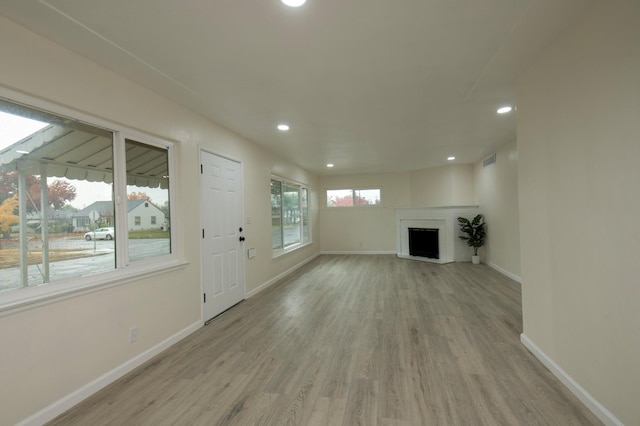 unfurnished living room with a fireplace and light hardwood / wood-style floors