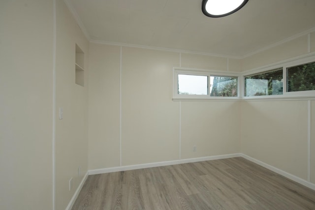 spare room featuring crown molding and light hardwood / wood-style flooring