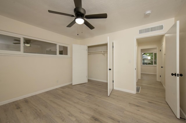 unfurnished bedroom featuring ceiling fan, light wood-type flooring, and a closet