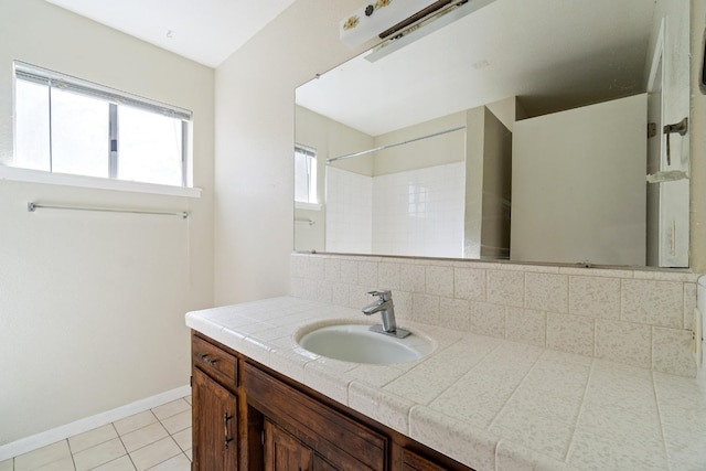 bathroom with walk in shower, vanity, tile patterned flooring, and tasteful backsplash