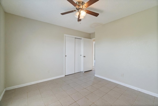 tiled spare room with ceiling fan