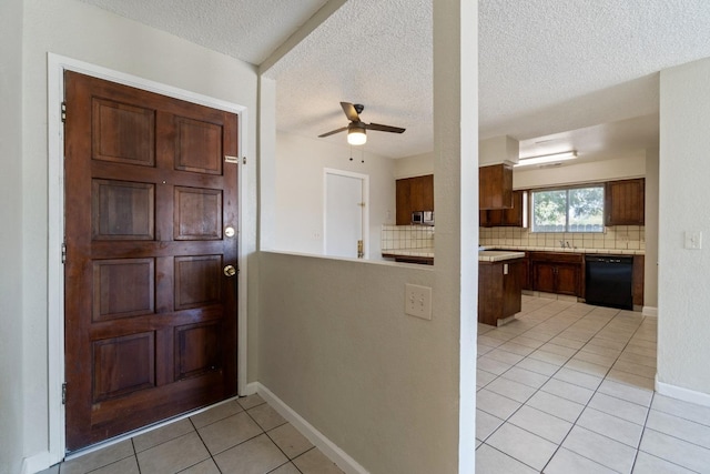 tiled foyer with a textured ceiling and ceiling fan